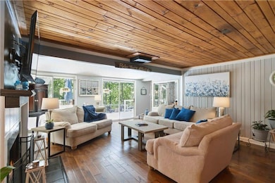 Living area with wood ceiling, dark wood-type flooring, and wood walls