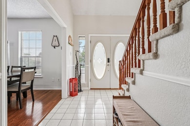 Foyer entrance with stairway, a textured ceiling,