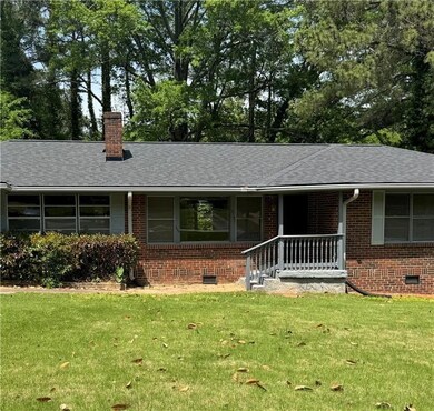 Single story home with brick siding, roof with shi