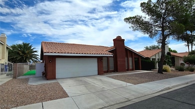 View of front of house with a garage, a tile roof,