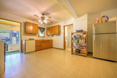 The spacious kitchen features wood cabinets, a dishwasher, and an electric range.