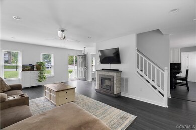 Living room featuring ceiling fan, a fireplace, an
