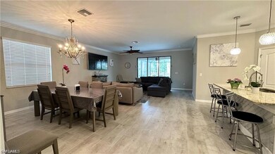 Dining room with ornamental molding, light wood-ty