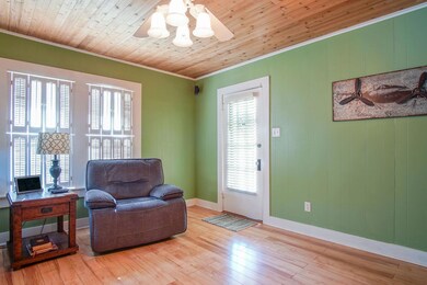 Living area with wooden ceiling, light hardwood / wood-style flooring, a wealth of natural light, and ceiling fan