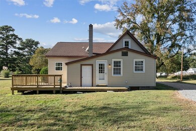 Back of property featuring a lawn and a wooden dec