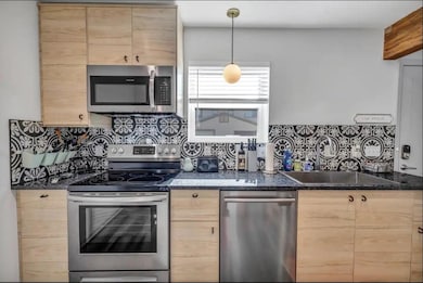 Kitchen featuring stainless steel appliances, lig
