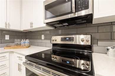 Kitchen with decorative backsplash, appliances wit
