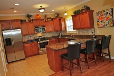 Large spacious kitchen with granite and tiled backsplash 