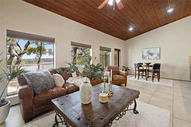 Living room featuring vaulted ceiling, light tile
