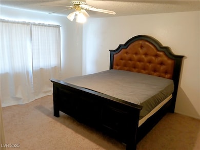 Carpeted bedroom with a ceiling fan