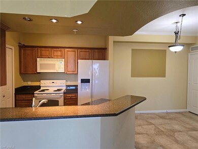 Kitchen with pendant lighting, white appliances, a