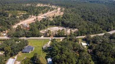 Aerial view of property and surrounding area featuring a forest