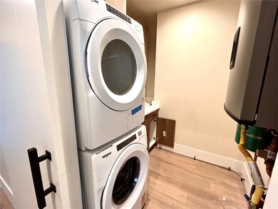 Washroom featuring estacked washer and dryer and l