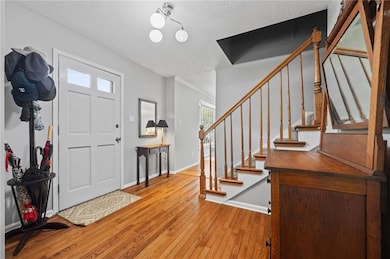 Foyer featuring hardwood / wood-style flooring and stairway