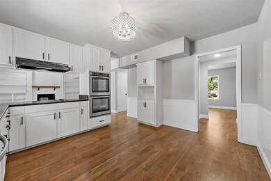 Kitchen with white cabinets, double oven, black el