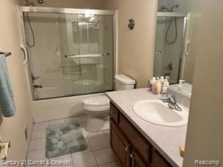 Bathroom featuring vanity, light tile patterned floors, and combined bath / shower with glass door