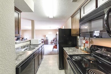 Kitchen with dark brown cabinets, black appliances