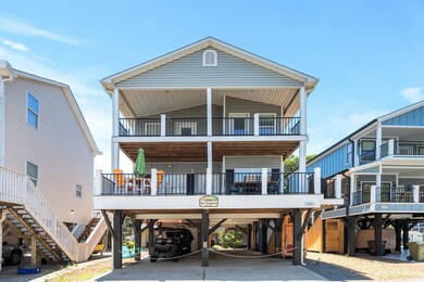 Coastal inspired home with a balcony, a carport, concrete driveway, and stairway
