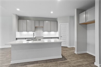 The open concept living room and kitchen makes for a great way to keep the party going and never miss a beat! Gather the family together in good conversation while preparing a fabulous meal in this breathtaking kitchen! Featuring high ceilings, light stained wood cabinets, quartz countertops, SS appliances, modern tile backsplash, recessed lighting, and kitchen island with ample counter space!