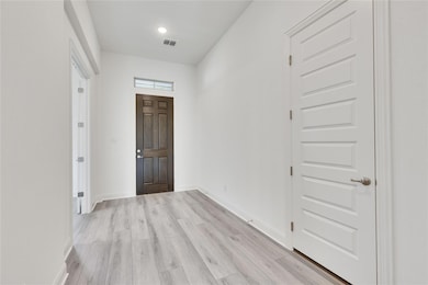 Entryway with light wood-style flooring and baseb