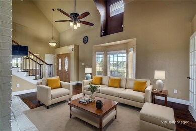 Front half of Living room featuring high vaulted ceiling, hardwood / wood-style floors, and see through wood burning fireplace.