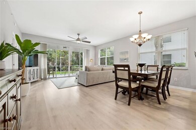 Dining room with ceiling fan with notable chandelier and light hardwood / wood-style floors