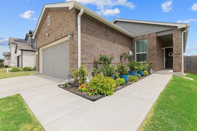 Ranch-style home featuring concrete driveway, a garage, brick siding, and a front yard