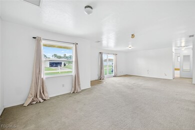 Empty room with plenty of natural light and tan colored carpet