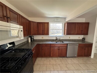 Kitchen with sink, dishwasher, black stove, and li