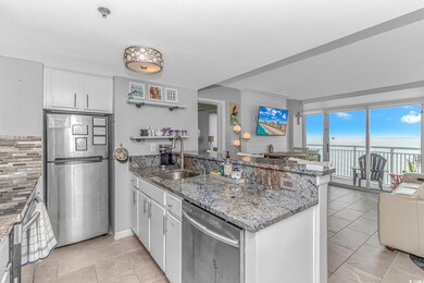Kitchen with white cabinetry, stone counters, sink