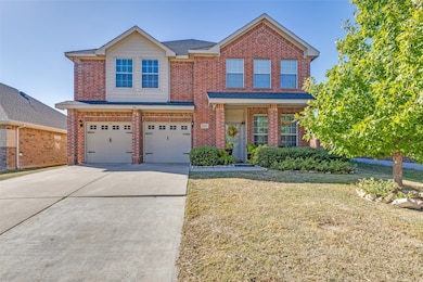 Traditional home with a front yard, concrete driveway, a garage, brick siding, and a shingled roof