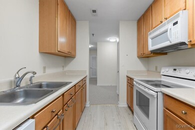 Kitchen featuring sink, white appliances, and ligh