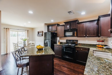Open kitchen with incredible island! Granite countertops and plenty of dining space.