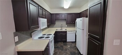 Kitchen featuring white appliances, a sink, decora
