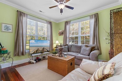 Living room with ornamental molding, wood-type flo