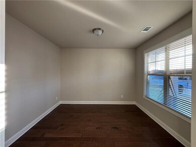 Spare room with baseboards, dark wood-type flooring, and visible vents