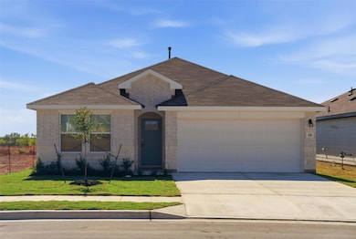 Single story home featuring brick siding, driveway, a garage, and a front lawn