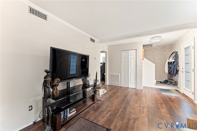 Living room with wood finished floors and crown molding