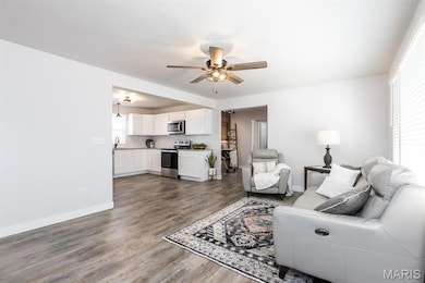 Living room featuring dark wood finished floors and a ceiling fan