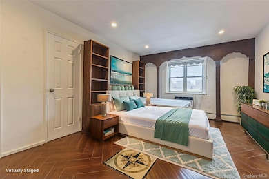 Bedroom featuring recessed lighting, arched walkways, an AC wall unit, and a baseboard radiator