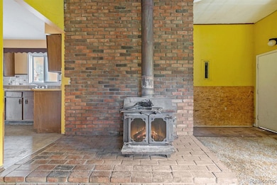 Detailed view of a wood stove, a wainscoted wall, and tasteful backsplash