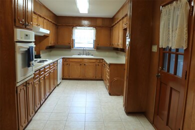 Kitchen featuring white appliances, light tile pat