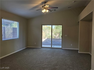 Empty room with a ceiling fan, visible vents, vaul