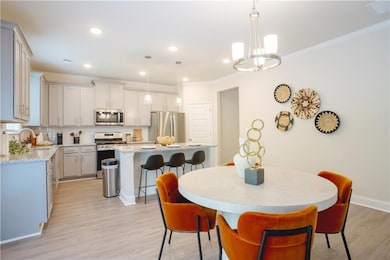 Dining room with light wood finished floors, ornamental molding, recessed lighting, and a chandelier