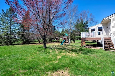View of grassy yard featuring stairway, a wooden d