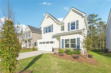 View of front of house with driveway, central AC, a garage, a front yard, and stone siding
