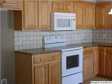 Eat in kitchen with custom wood cabinets, stone co