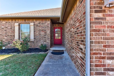 Property entrance with brick siding, roof with shingles, and a lawn