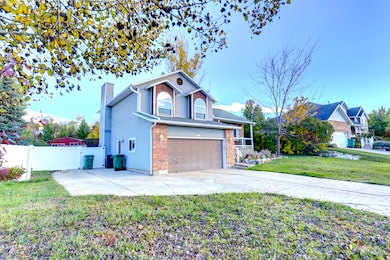 View of front of home with concrete driveway, a chimney, and an attached garage