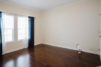 Empty room with ornamental molding and dark hardwo